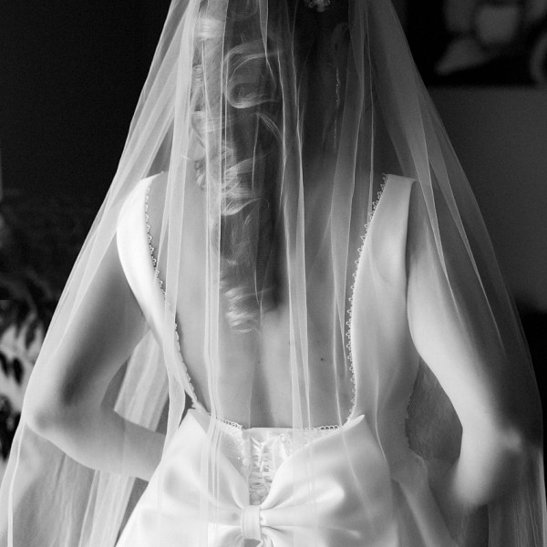 Fotka detailu chrbta nevesty s krasnym detailom masle na svadobnych satach