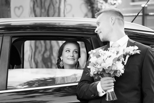 Svadobna momentka nevesty pozerajucej sa na zenicha z okna svadobneho auta