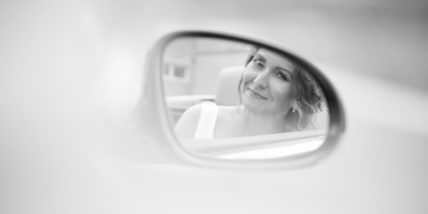 Portret nevesty odfotenej v spatnom zrkadielku svadobneho auta, letisko Dubova