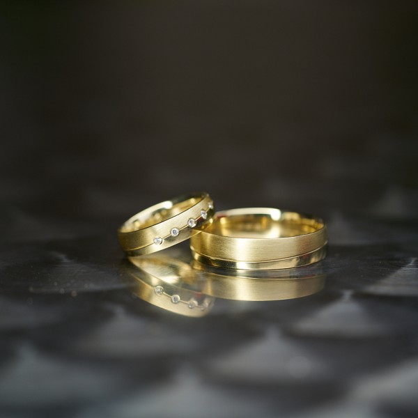 Svadobne prstene odfotene na lesklom metalickom povrchu